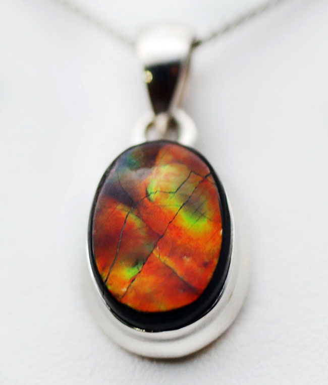 赤と思いきや鮮やかな緑が顔をのぞかせます!アンモライトを使ったペンダントトップ(Ammolite)。金具はスターリングシルバー。チェーン、革紐、ジュエリーケース付き(その3)
