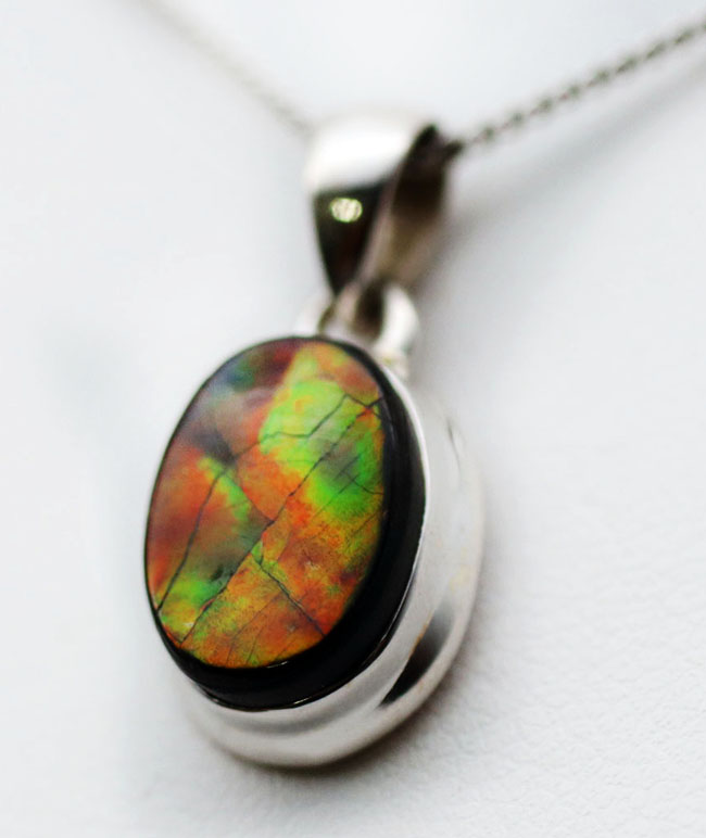 赤と思いきや鮮やかな緑が顔をのぞかせます!アンモライトを使ったペンダントトップ(Ammolite)。金具はスターリングシルバー。チェーン、革紐、ジュエリーケース付き(その4)