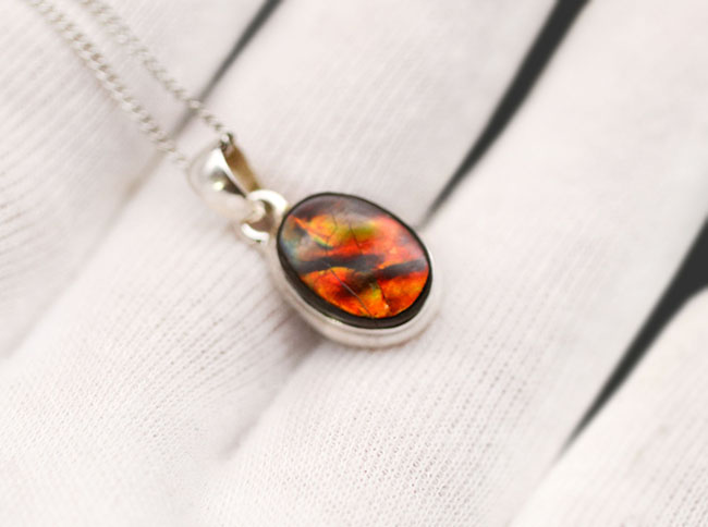 赤と思いきや鮮やかな緑が顔をのぞかせます!アンモライトを使ったペンダントトップ(Ammolite)。金具はスターリングシルバー。チェーン、革紐、ジュエリーケース付き(その5)